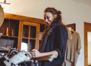 Designerin strickt an Flachstrickmaschine