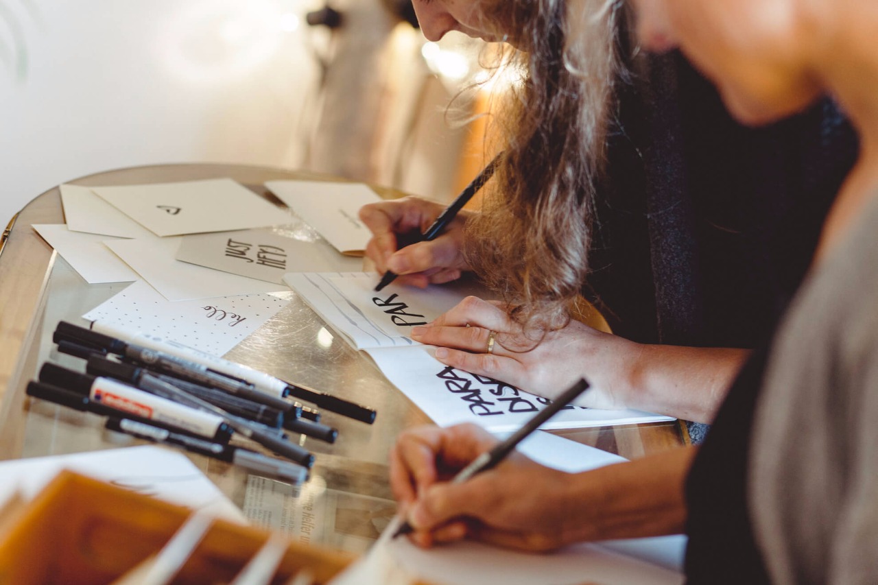 Grafik-Designerinnen bei der Arbeit an handgezeichneten Postkarten